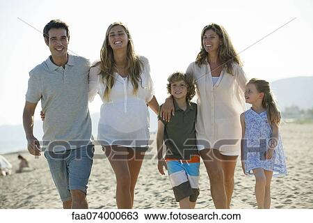 Stock Image - Family walking together at the beach. Fotosearch