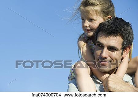Picture - Father carrying daughter on his shoulders. Fotosearch