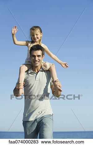 Father carrying daughter on his shoulders View Large Photo Image Stock Image - Father carrying daughter on his shoulders. Fotosearch