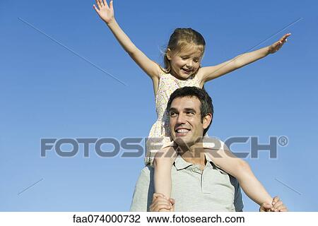 Father carrying daughter on his shoulders View Large Photo Image Stock Image - Father carrying daughter on his shoulders. Fotosearch