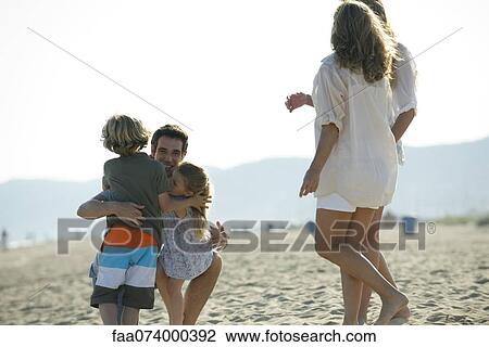 Father embracing young children at the beach View Large Photo Image Stock Image - Father embracing young children at the beach. Fotosearch