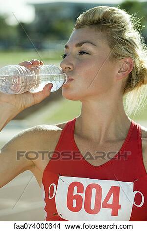 Female athlete drinking bottled water View Large Photo Image Picture - Female athlete drinking bottled water. Fotosearch