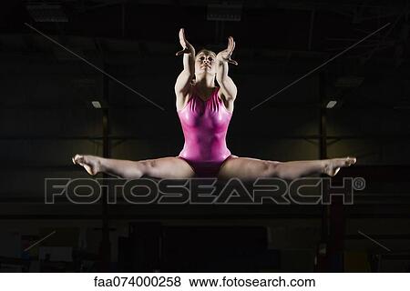 Female gymnast doing splits in midair View Large Photo Image Stock Photo - Female gymnast doing splits in midair. Fotosearch