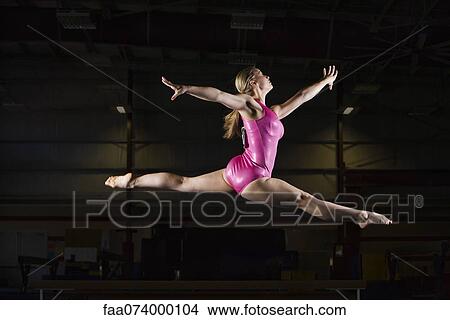 Female gymnast leaping in air View Large Photo Image Picture - Female gymnast leaping in air. Fotosearch