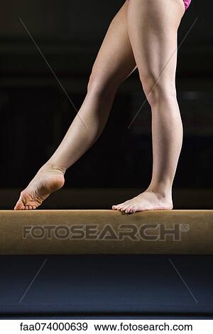 Stock Photo - Female gymnast on balance beam, low section. Fotosearch