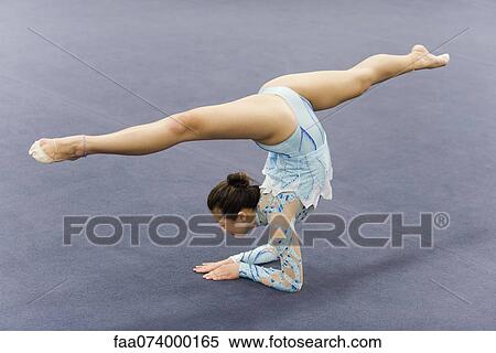 Stock Photography - Female gymnast performing elbow stand. Fotosearch