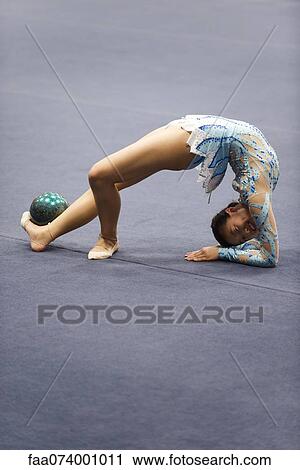 Female gymnast performing floor routine with ball View Large Photo Image Stock Image - Female gymnast performing floor routine with ball. Fotosearch