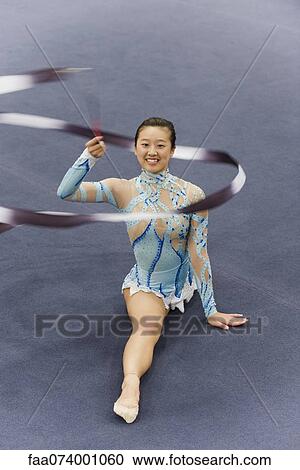 Female gymnast performing floor routine with ribbon View Large Photo Image Stock Image - Female gymnast performing floor routine with ribbon. Fotosearch