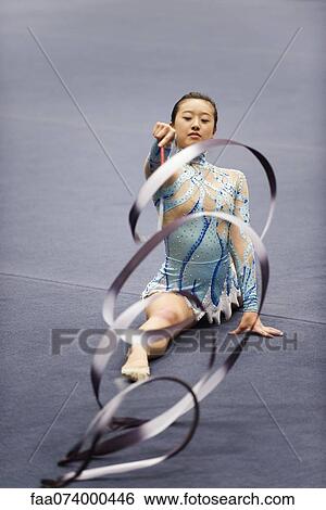 Female gymnast performing floor routine with ribbon View Large Photo Image Stock Photograph - Female gymnast performing floor routine with ribbon. Fotosearch