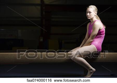Female gymnast sitting on balance beam, disappointed look on face View Large Photo Image Stock Photograph - Female gymnast sitting on balance beam, disappointed look on face. Fotosearch