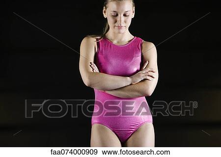 Female gymnast standing with arms folded across chest, looking down in disappointment View Large Photo Image Stock Photo - Female gymnast standing with arms folded across chest, looking down in disappointment. Fotosearch
