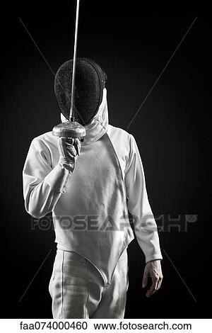 Stock Image - Fencer holding up foil, portrait. Fotosearch