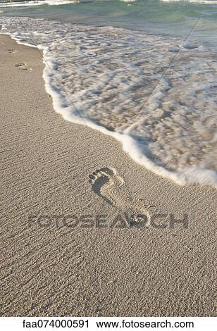 Stock Image - Footprint in sand, high angle view. Fotosearch