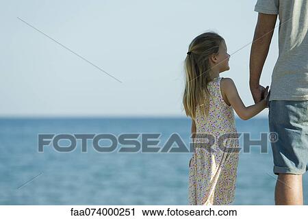 Girl holding her father's hand at the beach, cropped View Large Photo Image Stock Image - Girl holding her father's hand at the beach, cropped. Fotosearch