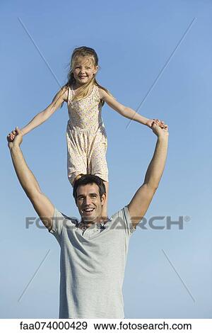 Girl standing on father's shoulders View Large Photo Image Stock Photo - Girl standing on father's shoulders. Fotosearch