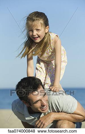 Little girl balancing on her father's back View Large Photo Image Stock Photo - Little girl balancing on her father's back. Fotosearch