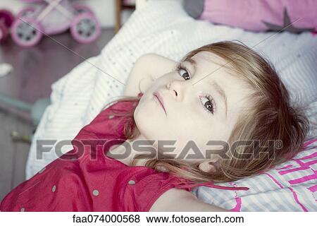 Stock Photo - Little girl reclining, portrait. Fotosearch