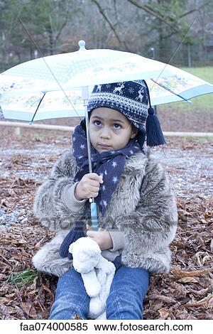 Little girl sitting under umbrella outdoors View Large Photo Image Stock Photography - Little girl sitting under umbrella outdoors. Fotosearch