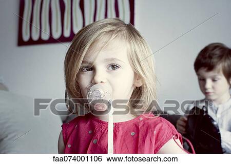 Stock Photograph - Little girl sucking pacifier. Fotosearch