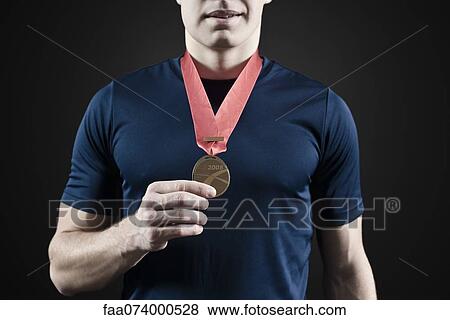 Male athlete holding medal, mid section View Large Photo Image Stock Photo - Male athlete holding medal, mid section. Fotosearch
