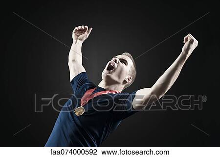 Male athlete shouting with arms raised in victory View Large Photo Image Stock Image - Male athlete shouting with arms raised in victory. Fotosearch