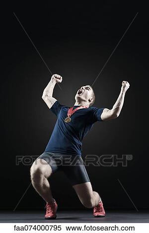 Male athlete shouting with arms raised in victory View Large Photo Image Stock Photography - Male athlete shouting with arms raised in victory. Fotosearch