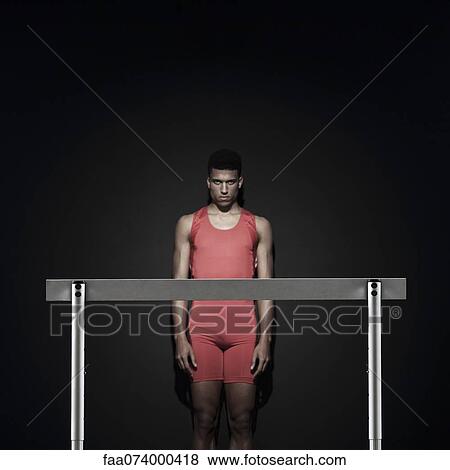Male athlete standing behind hurdle View Large Photo Image Stock Photo - Male athlete standing behind hurdle. Fotosearch