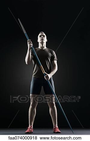Stock Photo - Male athlete standing with javeline. Fotosearch