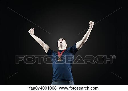 Male athlete with arms raised in victory View Large Photo Image Stock Photo - Male athlete with arms raised in victory. Fotosearch
