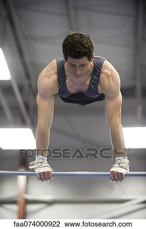 Stock Image - Male gymnast on horizontal bar. Fotosearch