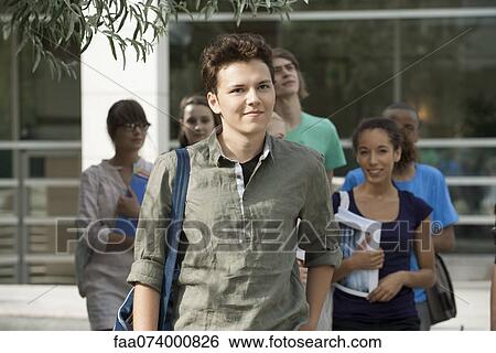 Stock Photograph - Male university student, friends in background. Fotosearch