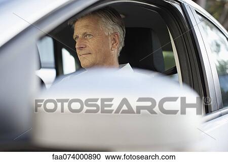 Stock Image - Man driving car, cropped. Fotosearch