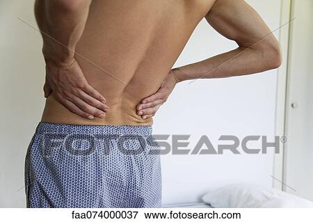 Man experiencing lower back pain, cropped View Large Photo Image Stock Photo - Man experiencing lower back pain, cropped. Fotosearch