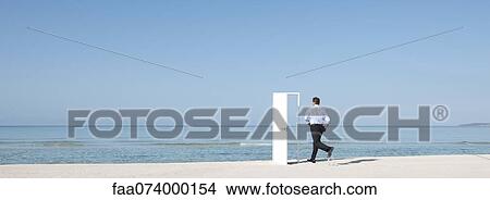 Man running on beach towards open door, rear view View Large Photo Image Picture - Man running on beach towards open door, rear view. Fotosearch