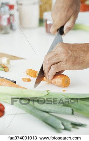 Stock Image - Man slicing fresh vegetables, cropped. Fotosearch
