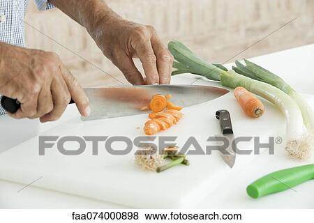 Man slicing fresh vegetables, cropped View Large Photo Image Stock Photo - Man slicing fresh vegetables, cropped. Fotosearch