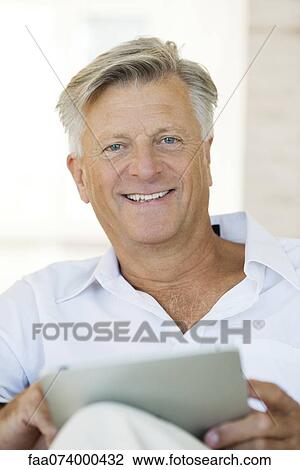 Stock Image - Man using digital tablet, portrait. Fotosearch