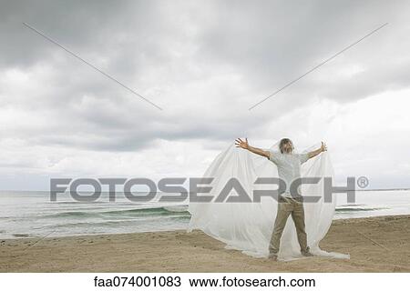 Stock Image - Man with arms outstretched trapped in plastic. Fotosearch