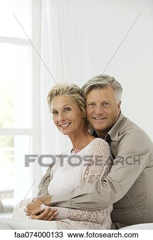 Stock Image - Mature couple embracing, portrait. Fotosearch
