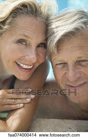 Picture - Mature couple relaxing together in pool, portrait. Fotosearch