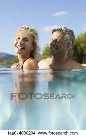 Picture - Mature couple relaxing together in pool. Fotosearch