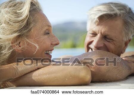 Picture - Mature couple relaxing together in pool. Fotosearch