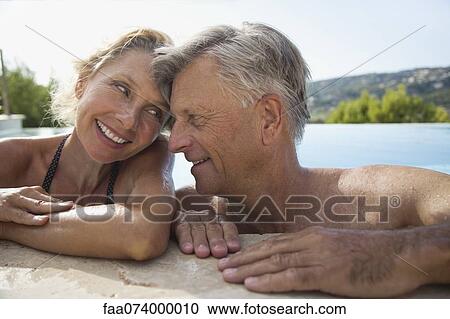 Mature couple relaxing together in pool View Large Photo Image Stock Image - Mature couple relaxing together in pool. Fotosearch