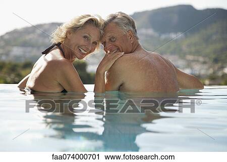 Mature couple relaxing together in pool View Large Photo Image Stock Image - Mature couple relaxing together in pool. Fotosearch