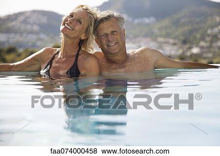Mature couple relaxing together in pool View Large Photo Image Stock Photo - Mature couple relaxing together in pool. Fotosearch