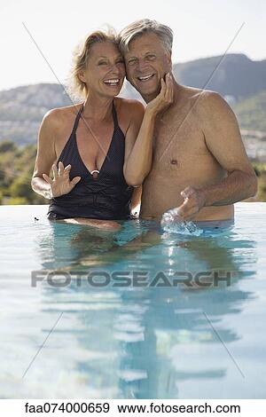 Stock Photo - Mature couple relaxing together in pool. Fotosearch