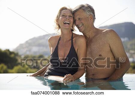 Mature couple relaxing together in pool View Large Photo Image Stock Photo - Mature couple relaxing together in pool. Fotosearch
