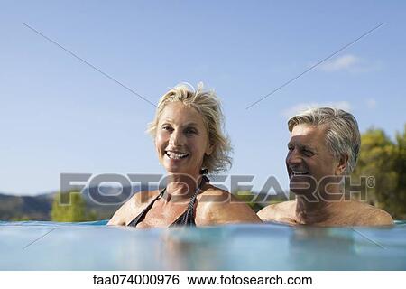 Mature couple relaxing together in pool View Large Photo Image Stock Photograph - Mature couple relaxing together in pool. Fotosearch