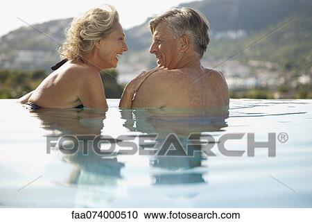 Mature couple relaxing together in pool, rear view View Large Photo Image Stock Image - Mature couple relaxing together in pool, rear view. Fotosearch