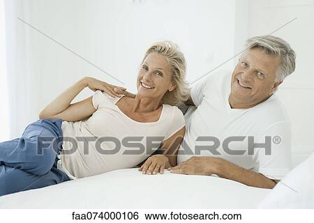 Mature couple relaxing together on bed, portrait View Large Photo Image Stock Photograph - Mature couple relaxing together on bed, portrait. Fotosearch